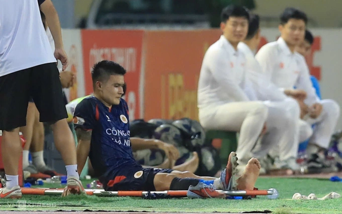 Nguyễn Quang Hải rời sân bằng cáng sau khi gặp chấn thương ở chân trái. Ảnh: Hoàng Huynh