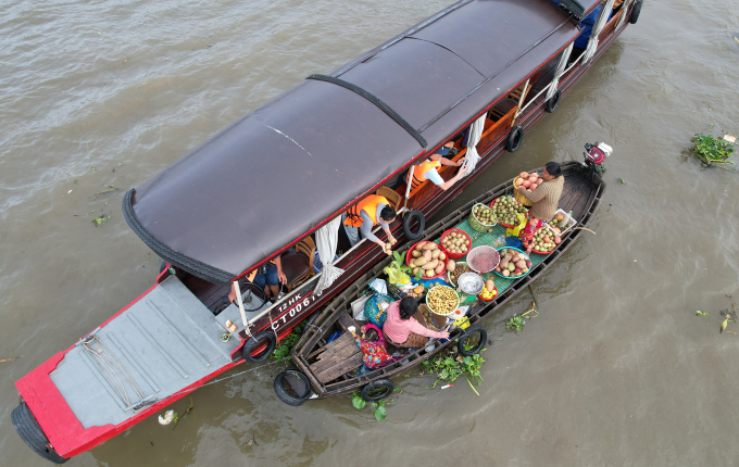 Du khách có thể thưởng thức hủ tiếu, trái cây trên ghe chợ nổi sáng sớm. Ảnh: Huy Phong