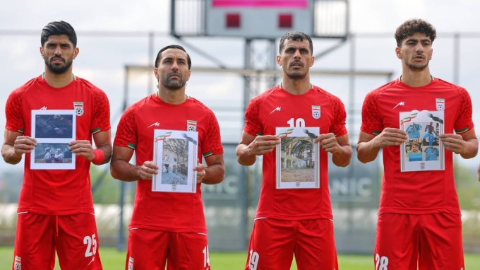 Cầu thủ Iran hát quốc ca, cầm ảnh những em nhỏ được cho là thiệt mạng trong các cuộc không kích của Mỹ và Israel tại Iran, trước trận giao hữu với Costa Rica tại Antalya, miền nam Thổ Nhĩ Kỳ, ngày 31/3/2026. Ảnh: AP