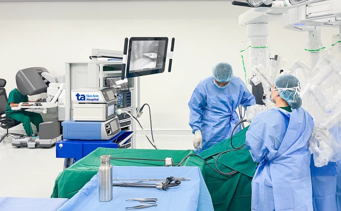 Phó giáo sư Vĩnh (bên trái) điều khiển robot Da Vinci Xi phẫu thuật cắt u tuyến ức cho người bệnh. Ảnh: Bệnh viện Đa khoa Tâm Anh
