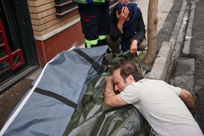 Một người đàn ông tại Tehran ôm thi thể người thân thiệt mạng trong vụ tập kích ngày 28/3 trúng vào khu dân cư. Ảnh: AP