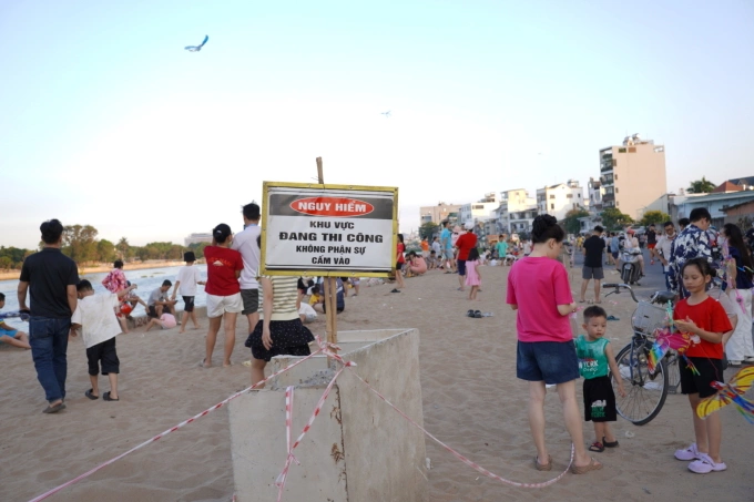 Người dân, du khách phớt lờ biển cảnh báo vào khu vực bãi cát để vui chơi. Ảnh: Tuấn Anh