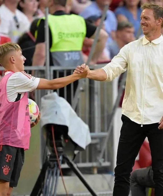 Lennart Karl trong vai trò nhặt bóng, bắt tay HLV Julian Nagelsmann trong một trận đấu của Bayern Munich năm 2022. Ảnh: Eurofoot