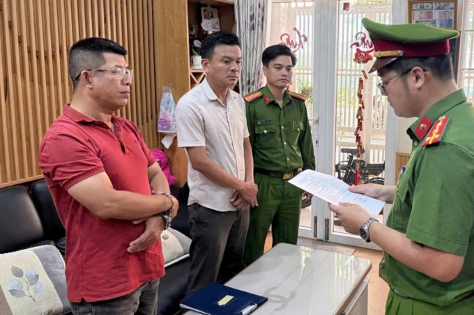 Nguyễn Lê Duy Dũng (áo đỏ) nghe đọc lệnh bắt tạm giam. Ảnh: Thành Huynh