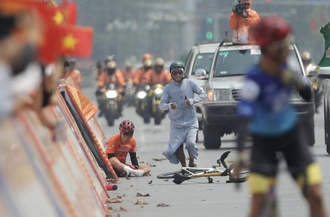 Người dân Nghệ An (mặc áo chống nắng) chạy tới giúp đỡ cua-rơ Nguyễn Văn Bình sau khi anh ngã ở đích đến chặng 5 giải xe đạp toàn quốc tranh Cup Truyền hình HTV 2025 từ Thanh Hóa đi Nghệ An, trưa 7/4. Ảnh: Như Huy